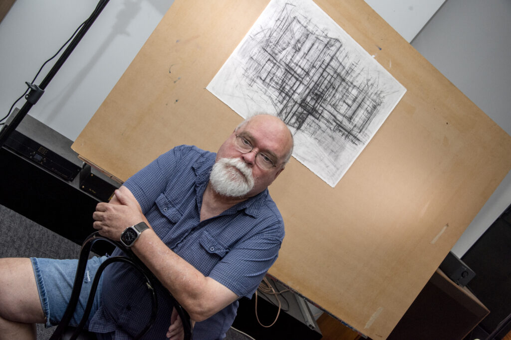 John Hart with the drawing that earned him a place as a finalist in the Dobell Drawing Prize, Photo by Noel Fisher