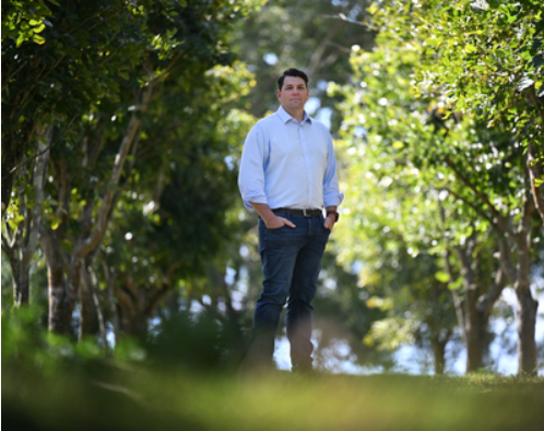 Rio Tinto Chief Decarbonisation Officer Jonathon McCarthy flanked by Pongamia trees.